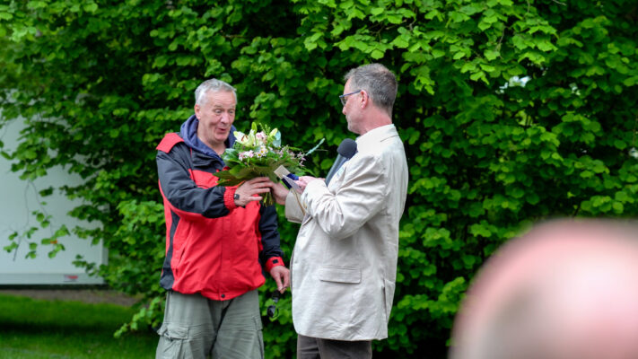 Bernd Kunert bekommt vom stellv. Heimleiter Nikolaus Thorndike Blumen und einen Gutschein als Gewinn überreicht.